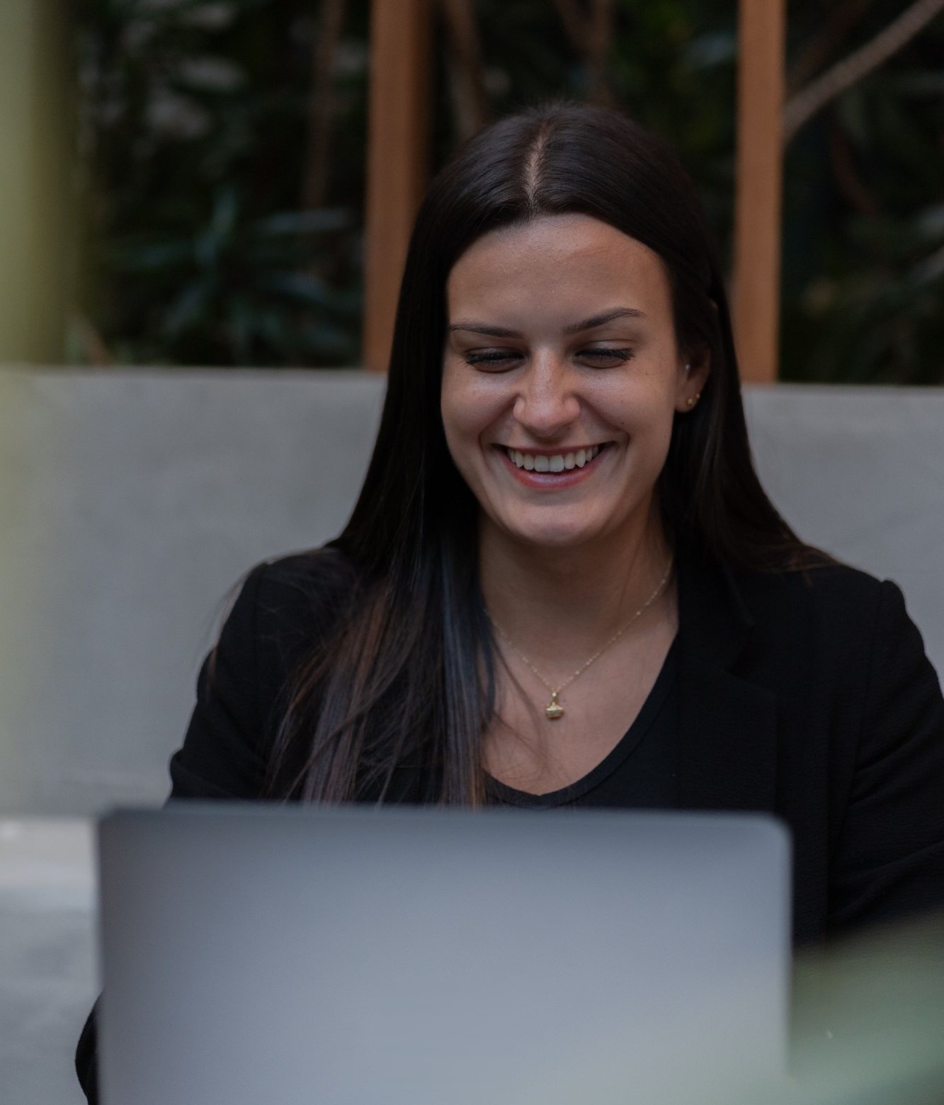An analyst smiling as she works on her laptop